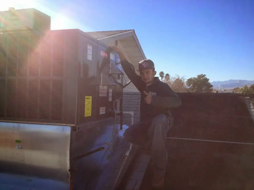 HVAC technician performing HVAC Inspection on a rooftop unit in The Dalles